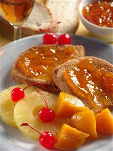 Ensalada de frutas y rebanadas de pan con mermelada. Receta disponible.                               
