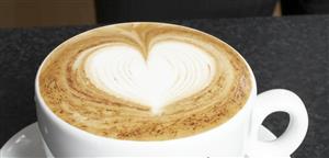 A cup of cappuccino with milk foam decorated with heart