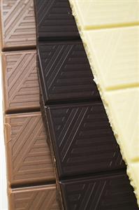 Pieces of three different chocolate bars (close-up)