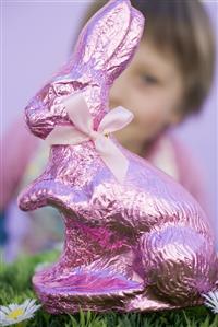 Easter Bunny in grass, child in background