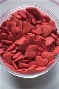 Pink sugar hearts in glass bowl (overhead view)