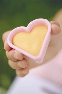 Child holding cut-out biscuit