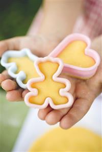 Child holding cut-out biscuits