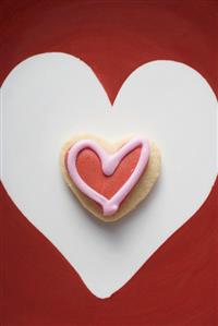 An iced, heart-shaped biscuit in a white heart