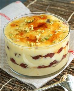Layered dessert with vanilla cream, cherries & pistachios