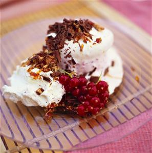 Ice cream dessert with redcurrants, cream & grated chocolate
