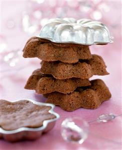 Mini chocolate cakes in a pile with baking tin