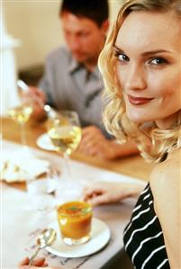 Man and woman at laid table with carrot and orange soup