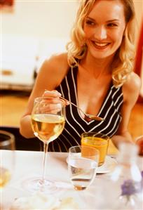 Young woman eating carrot and orange soup