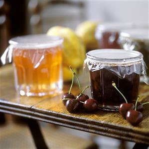 Cherry jam beside jar of quince jam