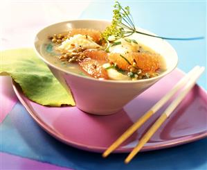 Fish and lentil stew with oranges in pink bowl