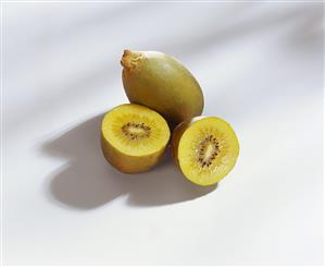 Yellow kiwi fruits, one halved