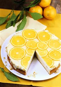 Orange cream cake with flaked almonds, a piece taken