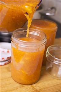 Pouring nectarine jam into jars