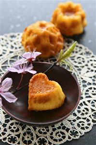 Small heart-shaped sponge cake with sprig of cherry blossom