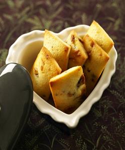 Honey and chocolate financiers in a heart-shaped china dish