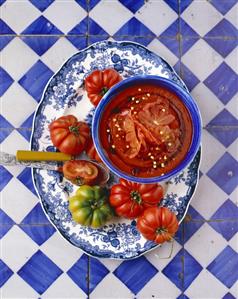 Tomato and pepper soup on a platter with tomatoes