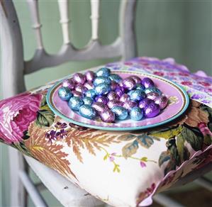 Small, foil-wrapped chocolate eggs on a plate