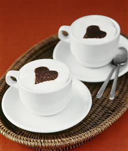 Two cups of cappuccino with hearts