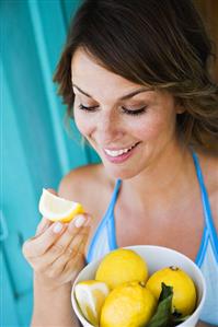 Woman holding a bowl of fresh lemons
