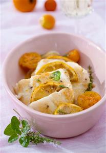 Fish with lemon, yellow tomatoes, rosemary and oregano