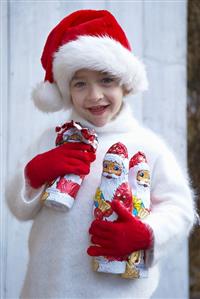 Boy in Father Christmas hat holding chocolate Father Christmases