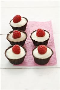 White chocolate mousse and raspberries in chocolate cases