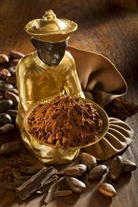 Gilded statuette with bowl of cocoa powder, cocoa beans