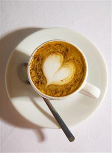 A cup of espresso macchiato with milk foam heart