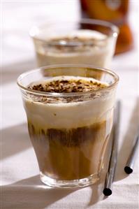 Two glasses of espresso with chocolate-nut liqueur and cream