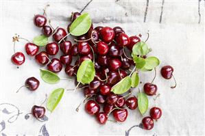 Cherries with leaves on linen cloth