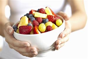 Woman holding a white bowl of berries