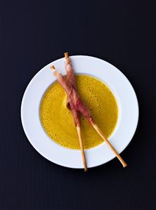 Curried courgette soup, grissini wrapped in prosciutto