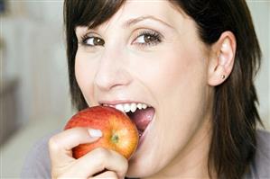 Young woman biting into an apple