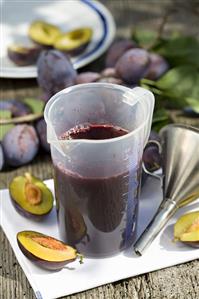 Plum juice in a measuring jug