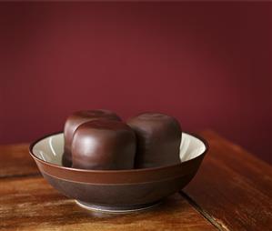 Three chocolate teacakes in brown bowl