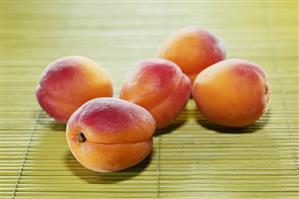 Five apricots on bamboo mat