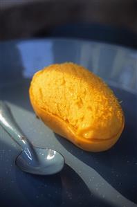 A mango, partly peeled