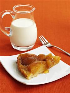 Piece of apple tart and jug of cream