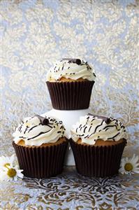 Muffins with cream topping and chocolate decorations