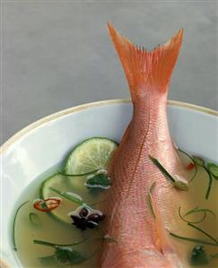 Broth with limes, herbs and whole fish