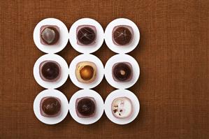 Eight Assorted Truffles with One Empty Paper Liner