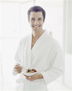 Man in bathrobe with healthy breakfast smiling