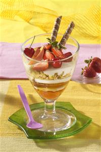 Yogur con frutos rojos, miel y muesli. Receta disponible.
