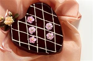 Corazon de chocolate y marron glace adornado con flores. Receta disponible.