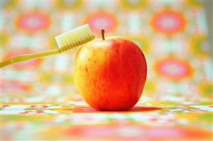 Toothbrush balancing on apple